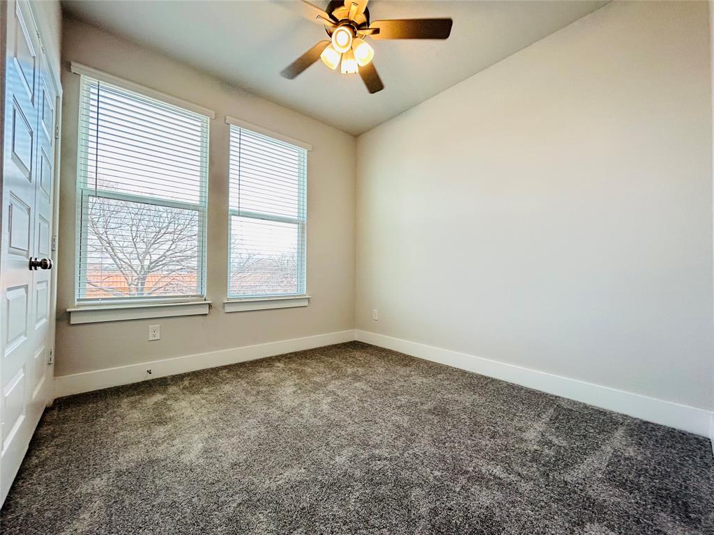 760 West Bedford Euless Road, Unit 214 Hurst, TX 76053 - Photo 30 of 32 an empty room with chandelier fan and windows