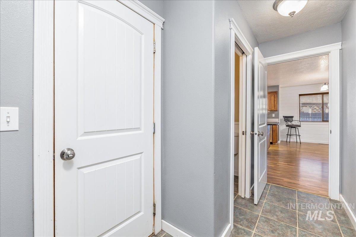 237 16th Avenue North Payette, ID 83661 - Photo 16 of 36 Corridor featuring a textured ceiling, a textured wall, and dark tile patterned flooring