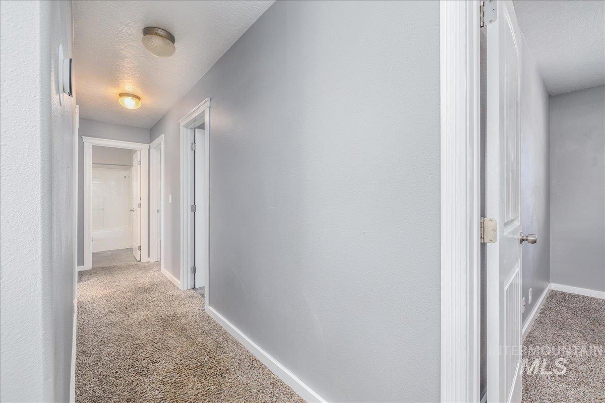 237 16th Avenue North Payette, ID 83661 - Photo 17 of 36 Hallway with light carpet and a textured ceiling