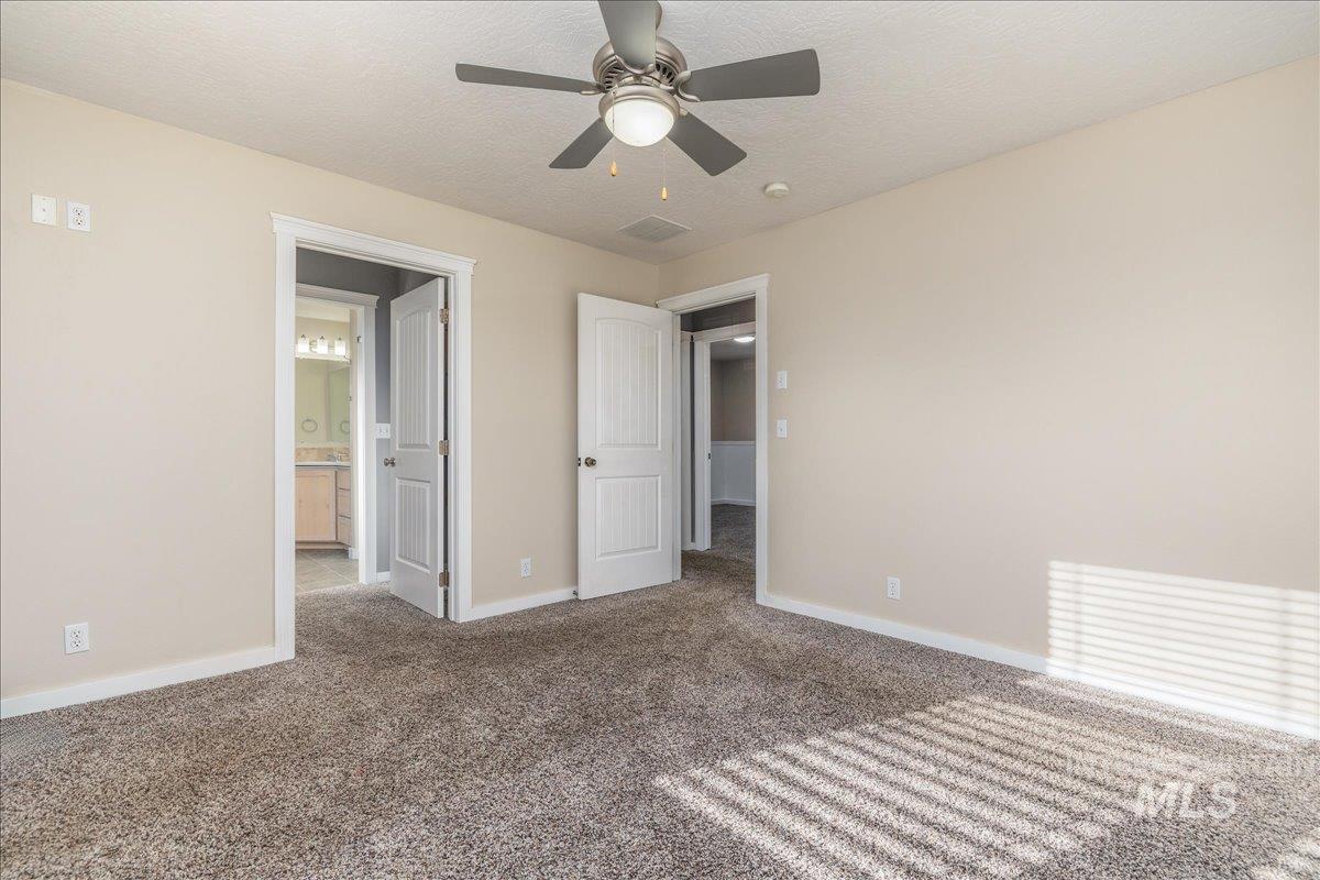 237 16th Avenue North Payette, ID 83661 - Photo 22 of 36 Unfurnished bedroom with a textured ceiling, carpet flooring, a ceiling fan, and ensuite bathroom