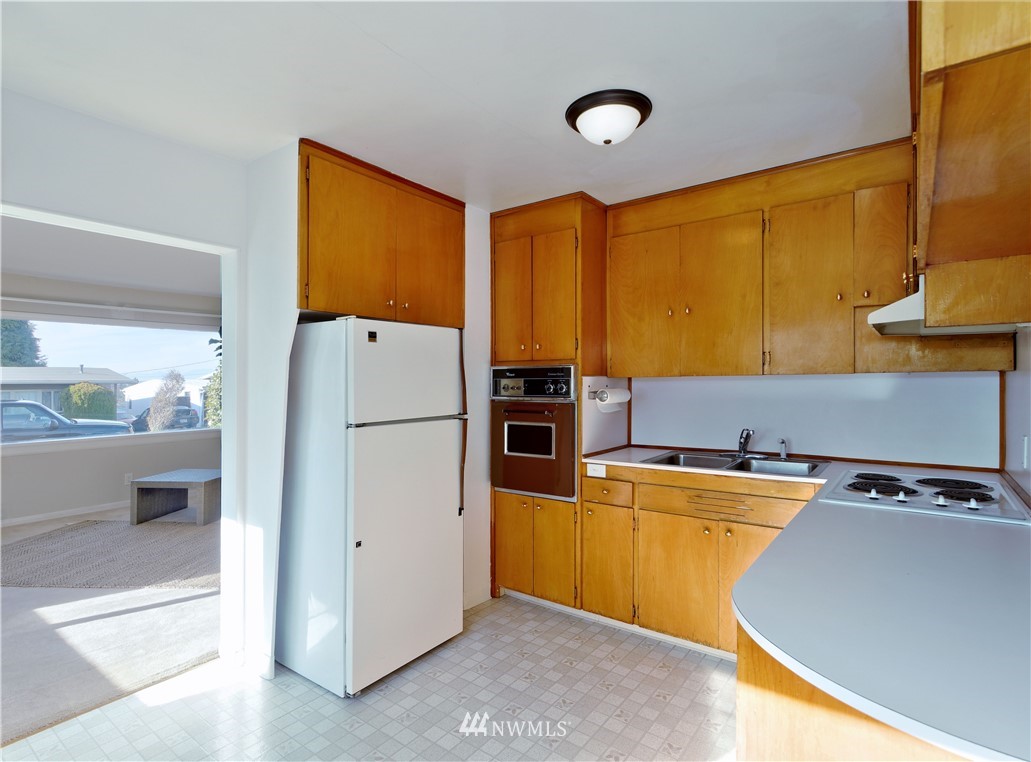 2189 Northeast 9th Place Renton, WA 98056 - Photo 5 of 21 a kitchen with a refrigerator a stove top oven a sink and a dining table