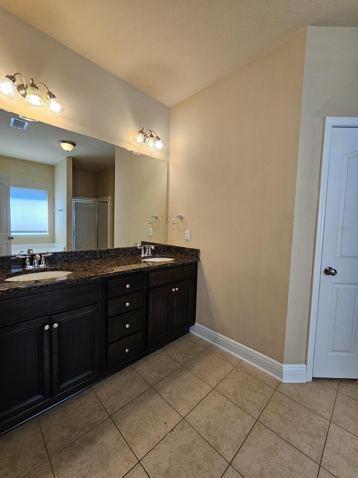 660 Red Fern Road Crestview, FL 32536 - Photo 11 of 22 a spacious bathroom with a double vanity sink and a mirror