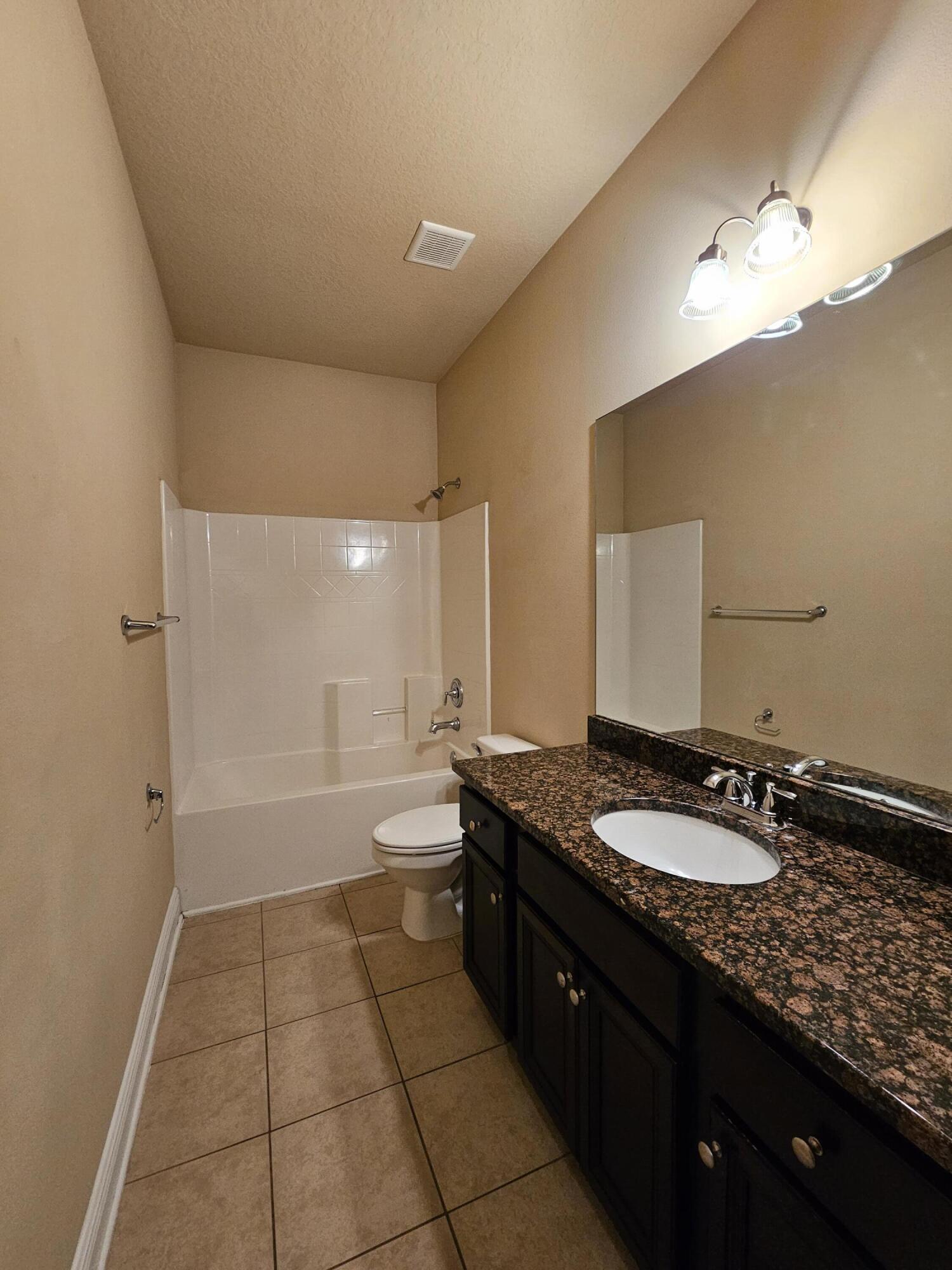 660 Red Fern Road Crestview, FL 32536 - Photo 15 of 22 a bathroom with a granite countertop sink a toilet a mirror and bathtub