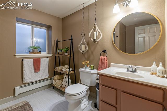 11170 Peaceful Valley Road Colorado Springs, CO 80925 - Photo 31 of 49 Bathroom featuring baseboard heating and vanity