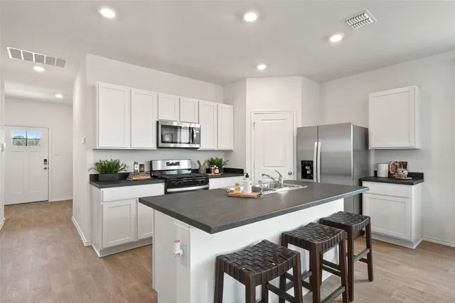 a kitchen with refrigerator cabinets and wooden floor