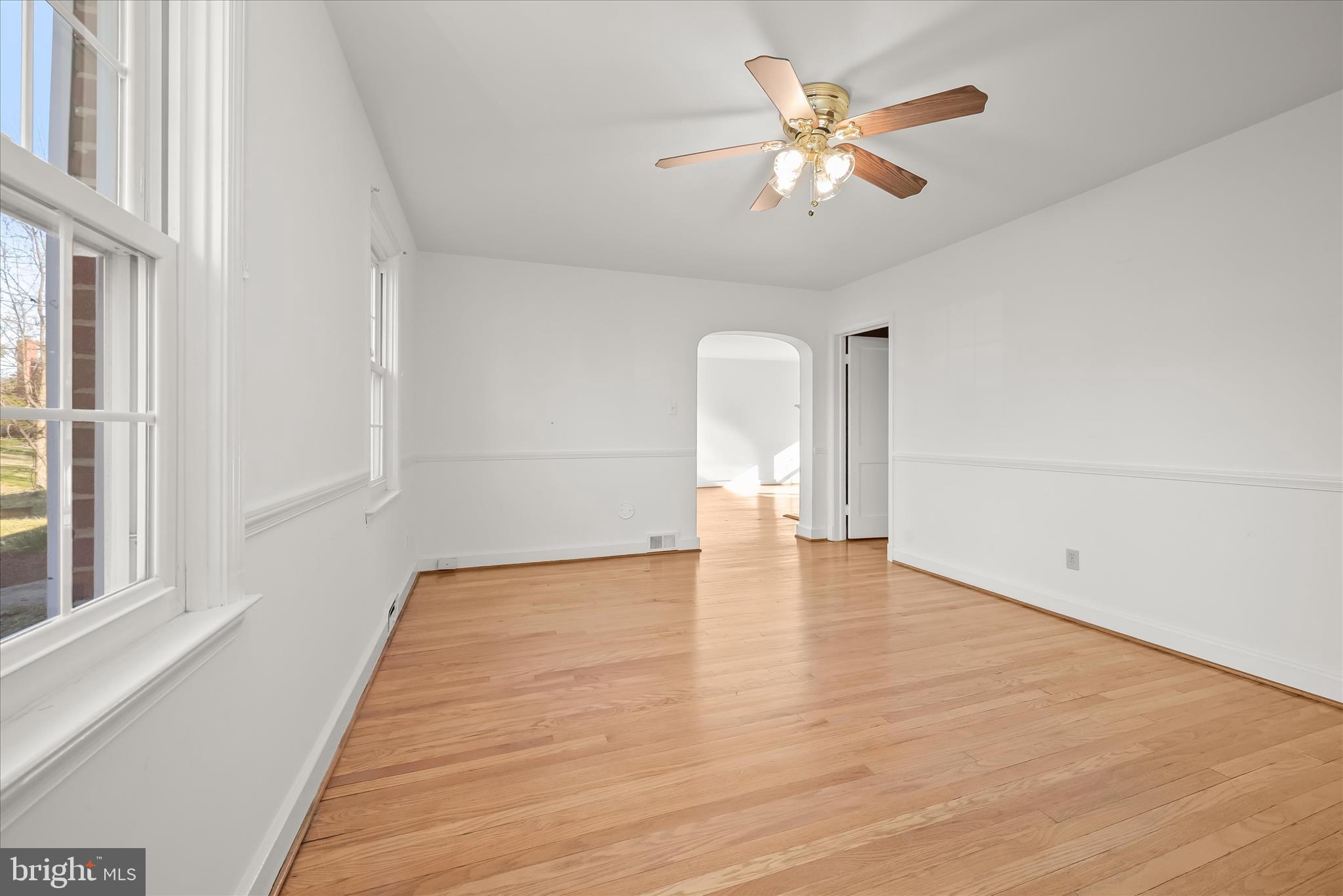3637 Sussex Road Pikesville, MD 21207 - Photo 15 of 33 a view of an empty room with a window and wooden floor