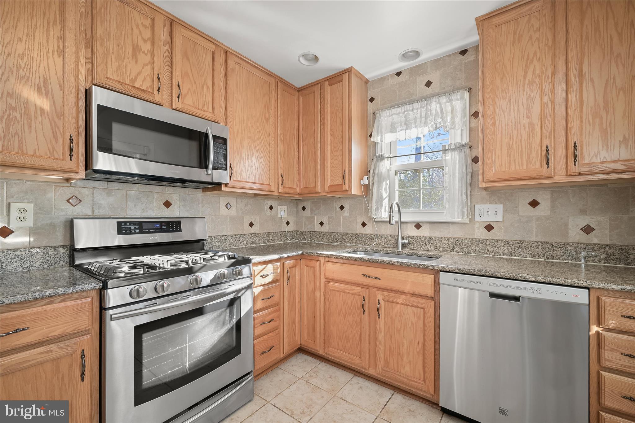 3637 Sussex Road Pikesville, MD 21207 - Photo 18 of 33 a kitchen with granite countertop a sink cabinets and stainless steel appliances