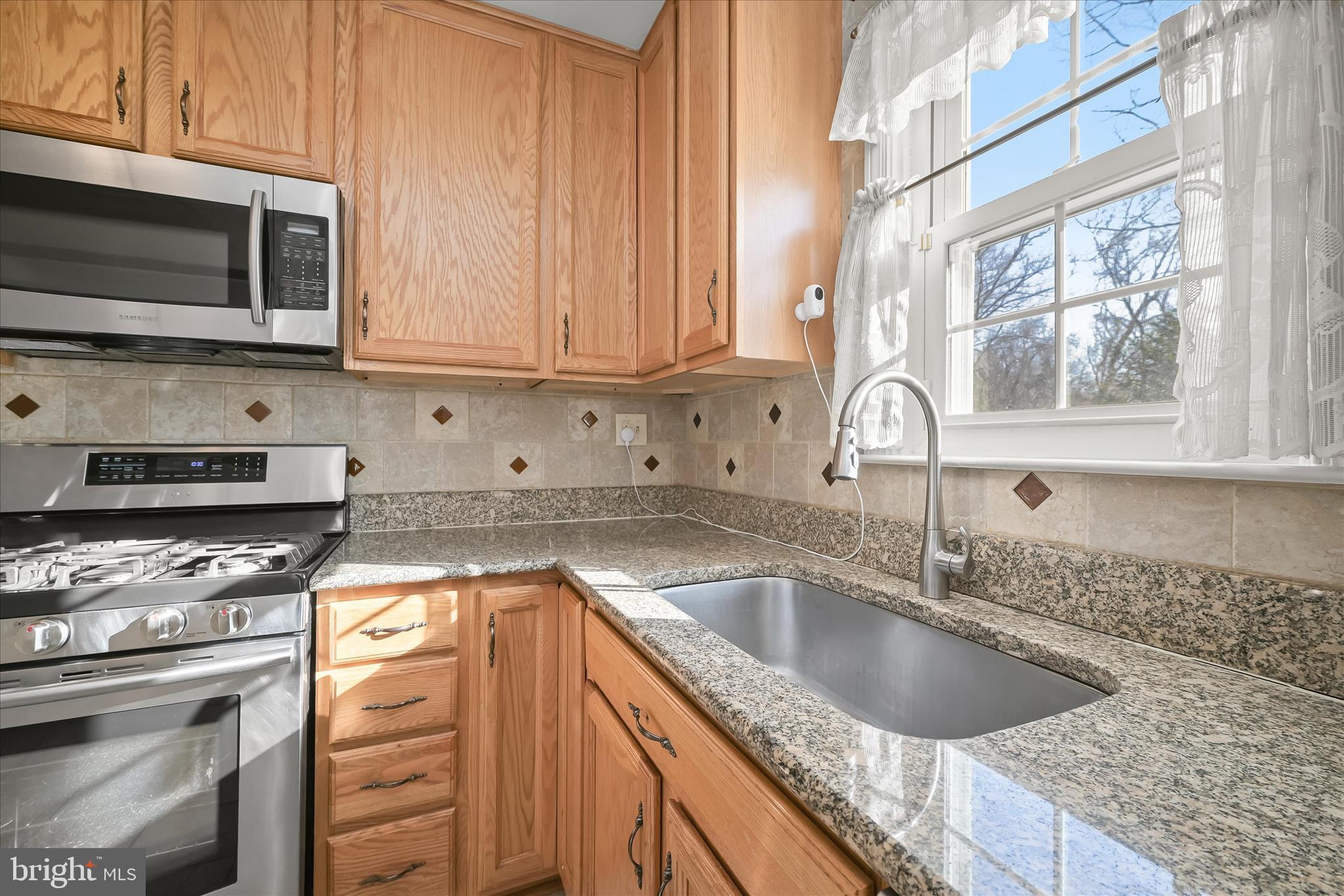 3637 Sussex Road Pikesville, MD 21207 - Photo 19 of 33 a kitchen with granite countertop a sink a stove and microwave