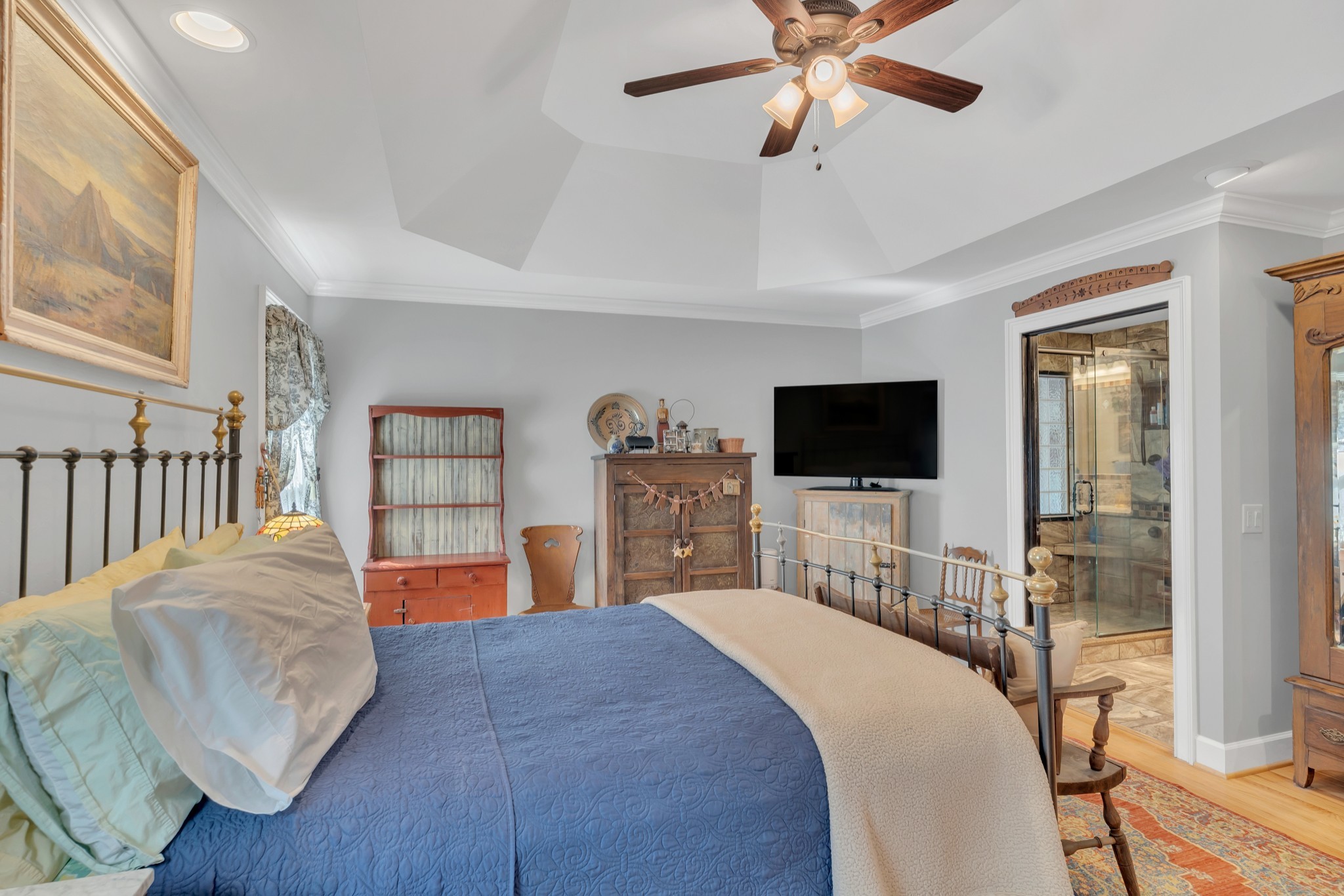 7197 Highland Road Portland, TN 37148 - Photo 23 of 92 a bedroom with a bed a flat screen tv and a chandelier