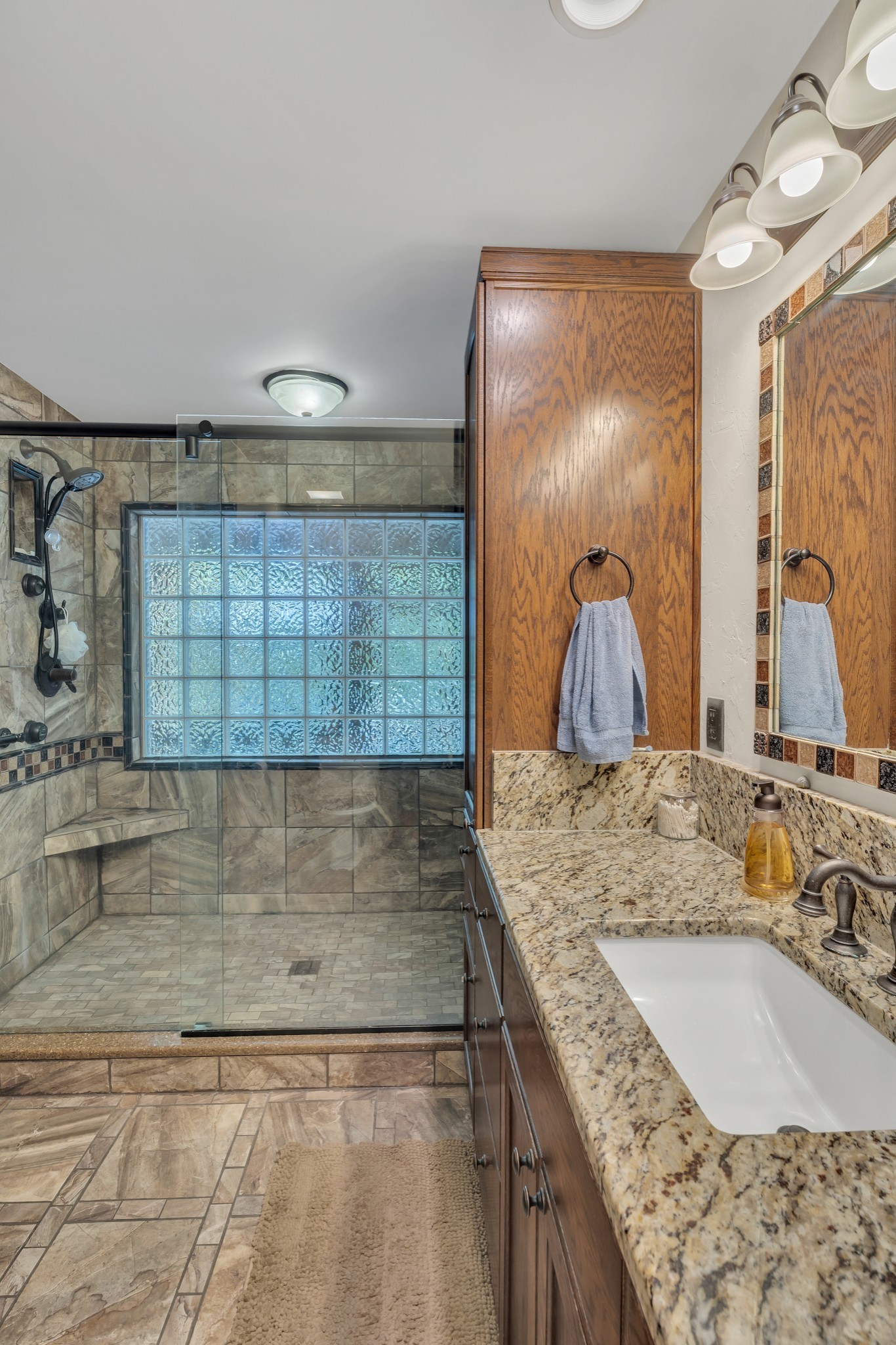 7197 Highland Road Portland, TN 37148 - Photo 25 of 92 a bathroom with a granite countertop sink a mirror and shower