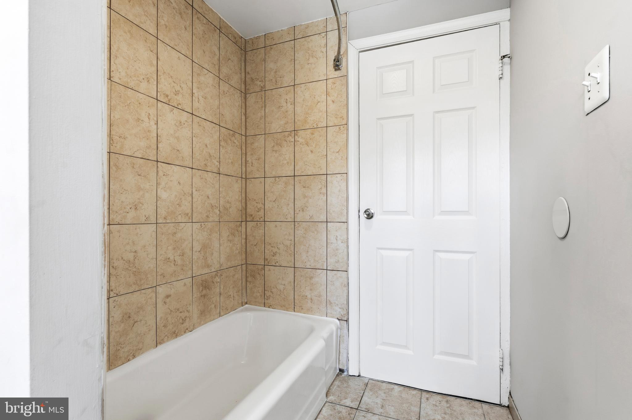 7713 Burnside Road Landover, MD 20785 - Photo 18 of 23 Modern bathroom with tiled walls and tub.