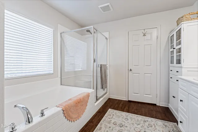 a bathroom with a tub shower and sink