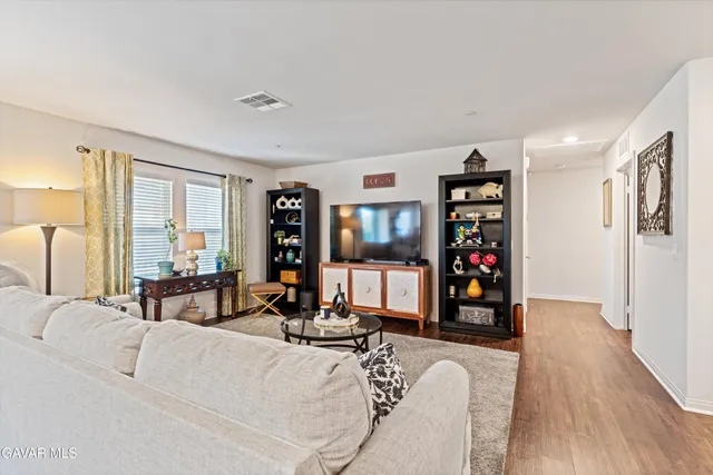 a living room with furniture a lamp and a large window