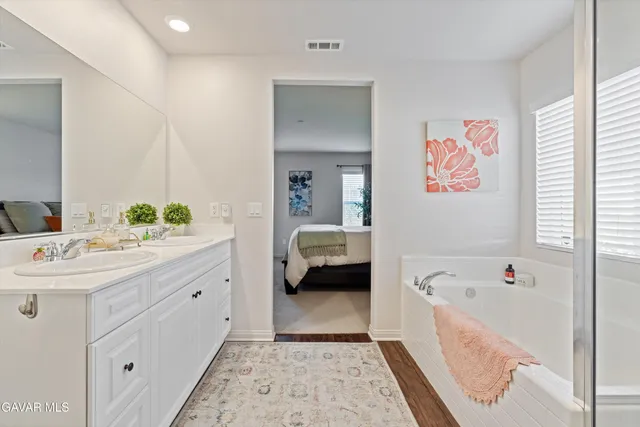 a en suite spacious bathroom with a tub sink and mirror