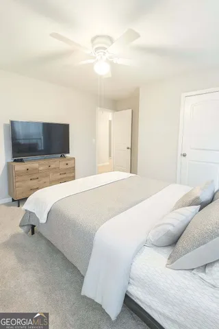 a bedroom with a large bed and a flat tv screen on a dresser