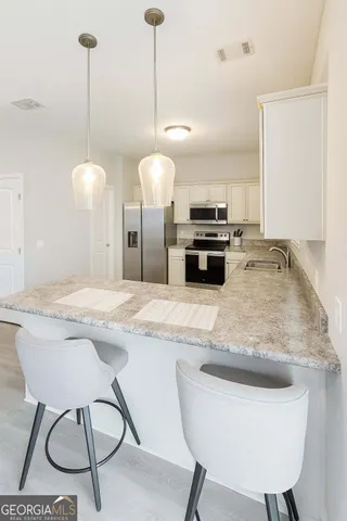 a kitchen with kitchen island a counter and chairs