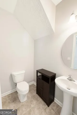 a bathroom with a toilet a sink and mirror