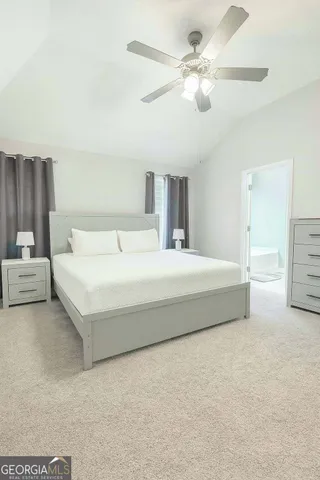 a spacious bedroom with a bed and a chandelier