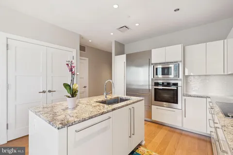 a kitchen with granite countertop kitchen island white cabinets and white appliances