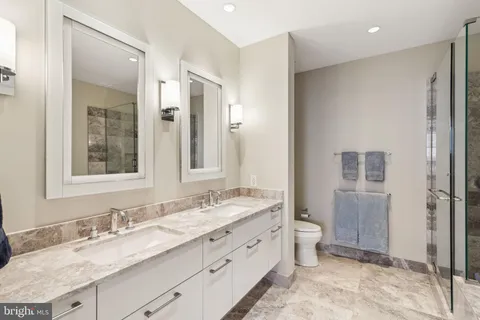 a bathroom with a granite countertop sink mirror and a toilet
