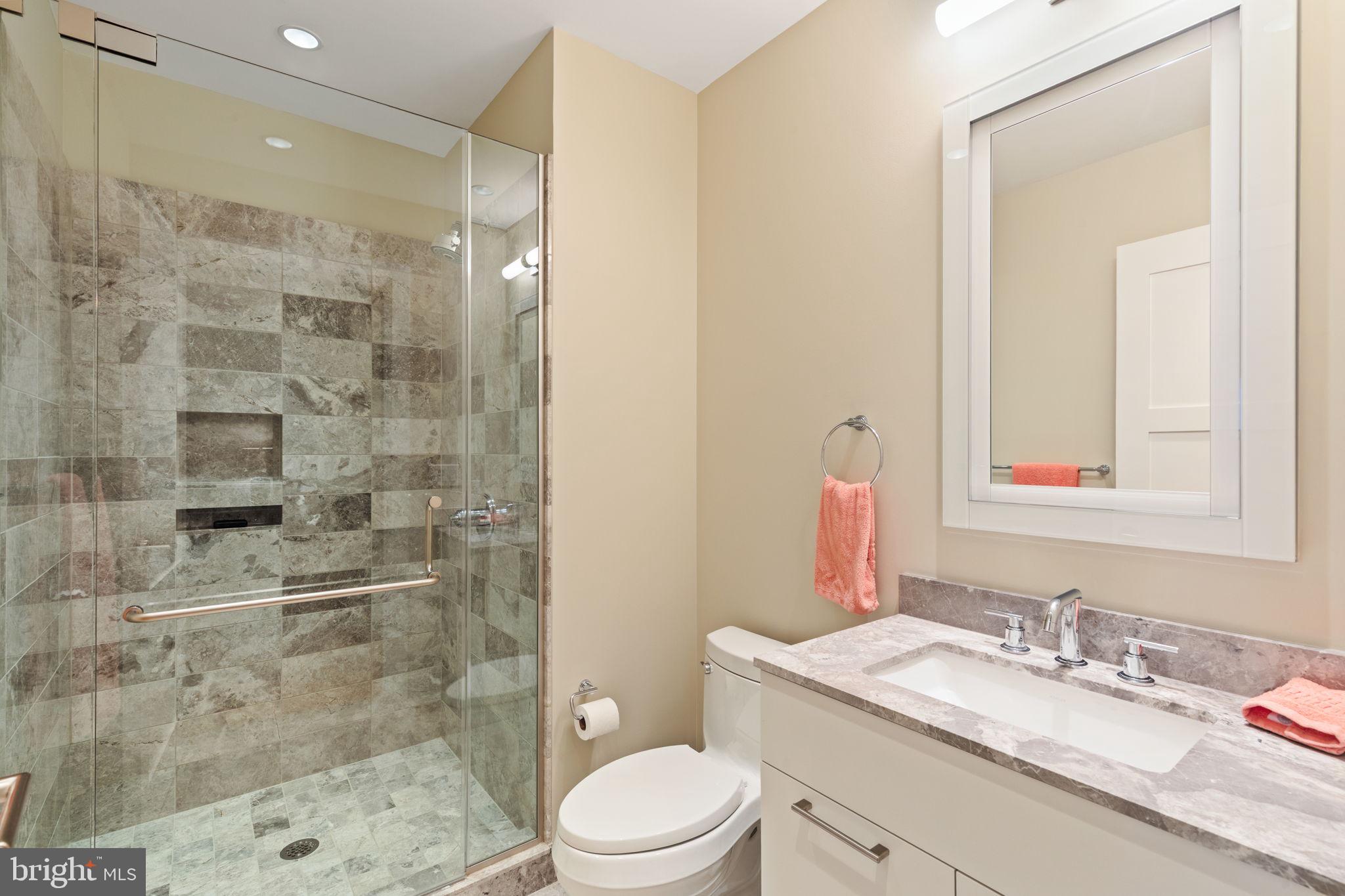 50 South 16th Street, Unit 5306 Philadelphia, PA 19103 - Photo 20 of 40 a bathroom with a granite countertop sink toilet a mirror a vanity and shower