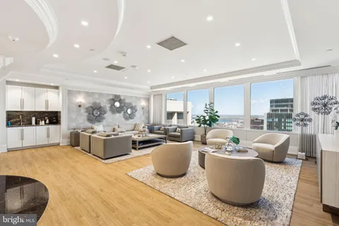 a living room with furniture a rug kitchen view and a faucet
