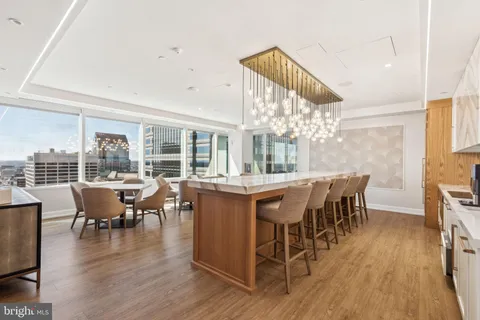 a dining room with wooden floor a chandelier a wooden table and chairs
