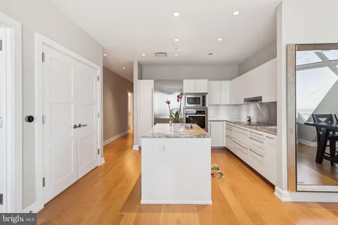 a large white kitchen with stainless steel appliances