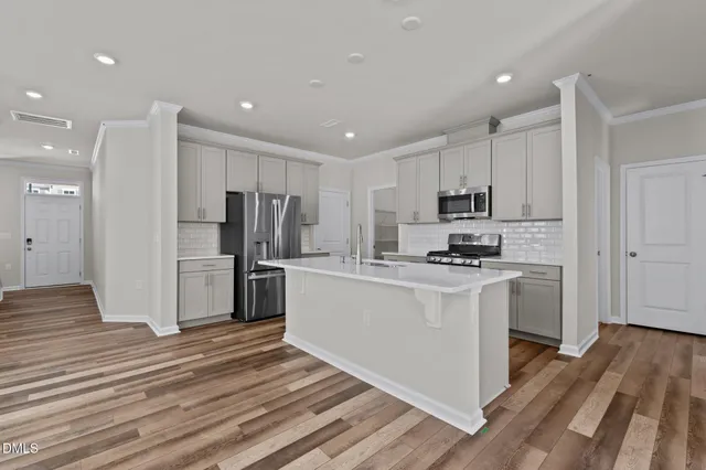 a kitchen with kitchen island a refrigerator sink and cabinets