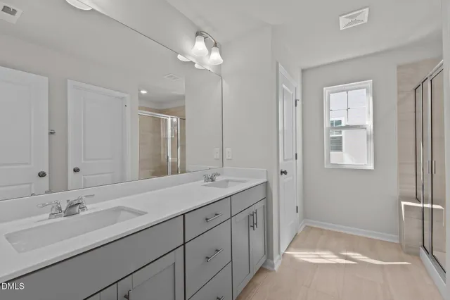 a spacious bathroom with a double vanity sink and a mirror