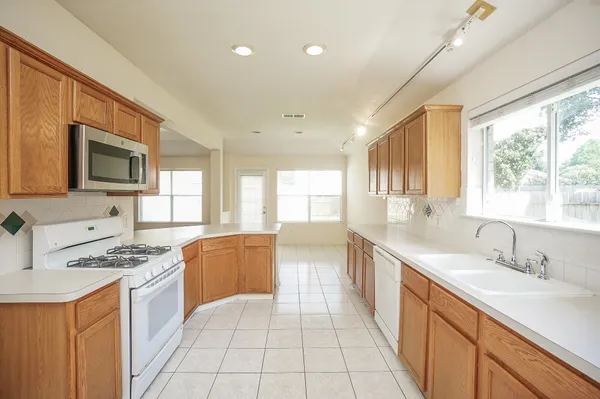 a large kitchen with stainless steel appliances granite countertop a sink and cabinets