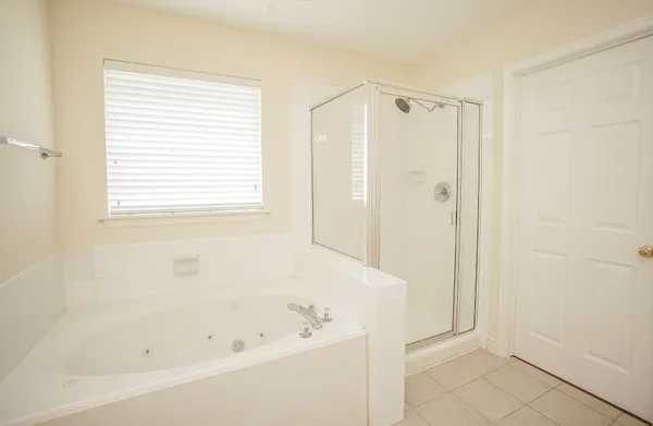 a white bath tub sitting next to a shower