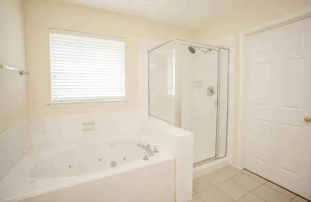a white bath tub sitting next to a shower