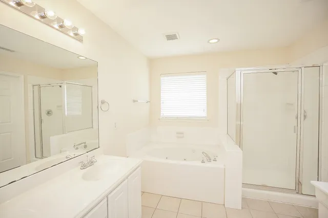 a bathroom with a bathtub a sink a vanity and a shower
