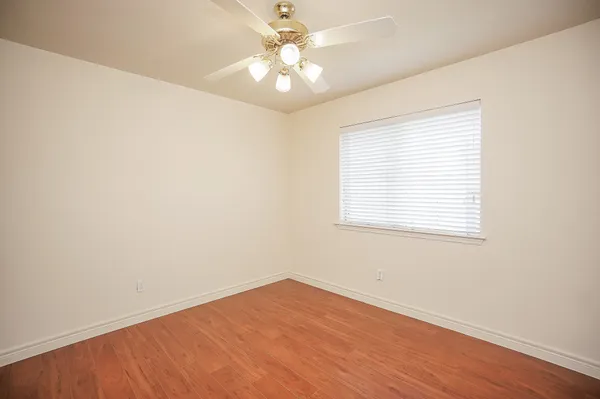 an empty room with a window and a ceiling fan
