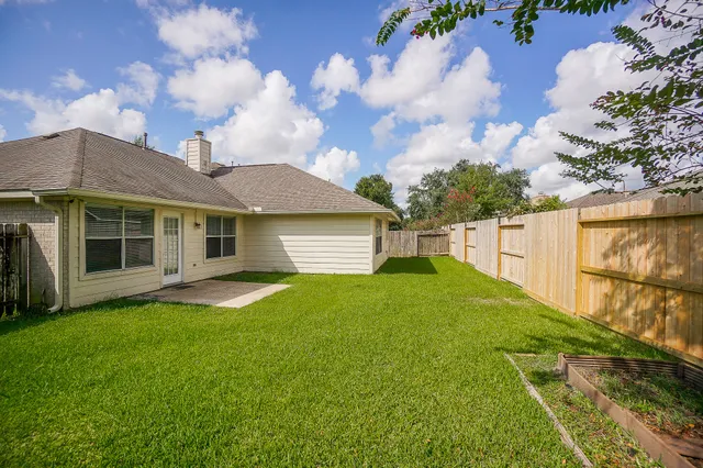 a view of a yard in front of a house with a large tree