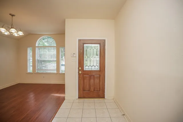 a view of an entryway with wooden floor and a chandelier