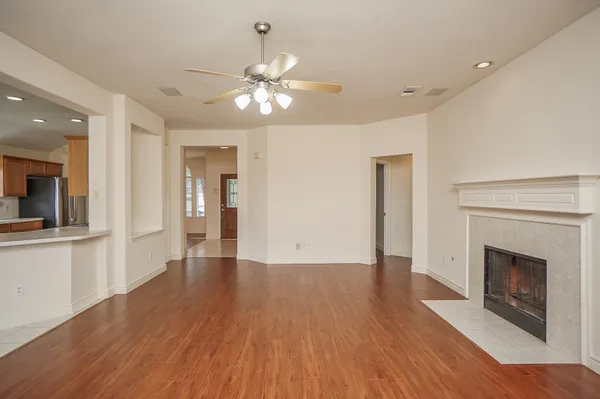 a view of a livingroom with wooden floor and a kitchen