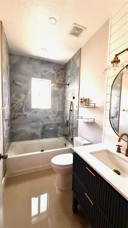 a bathroom with a double vanity sink toilet mirror and bathtub