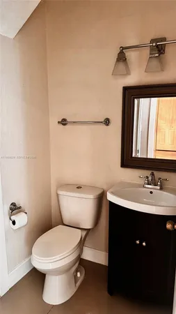 a bathroom with a toilet a sink and mirror