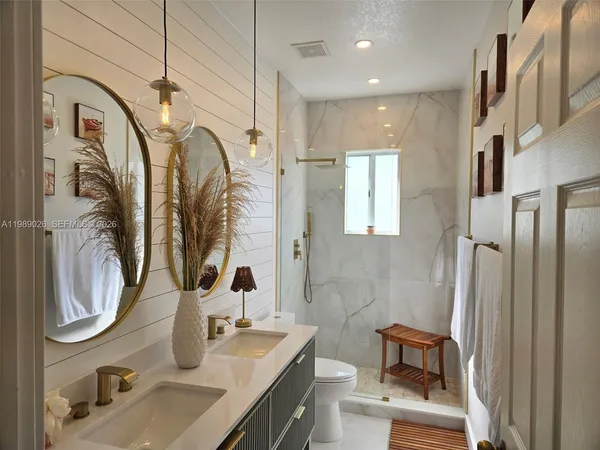 a bathroom with a sink a toilet and a mirror