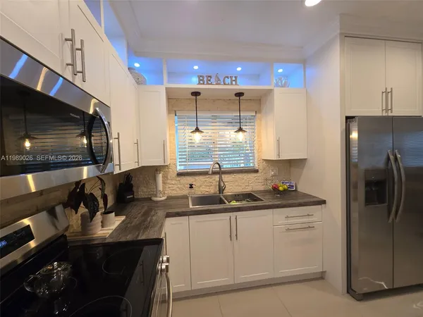 a kitchen with stainless steel appliances a sink stove and refrigerator