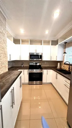 a kitchen with stainless steel appliances granite countertop a sink and white cabinets