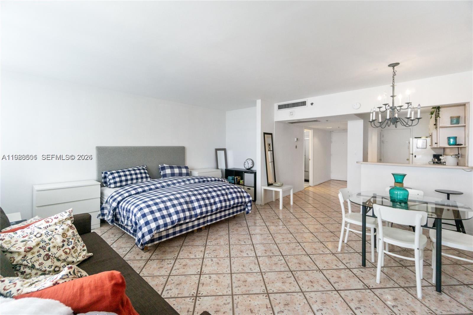 100 Lincoln Road, Unit 818 Miami Beach, FL 33139 - Photo 2 of 18 a bedroom with a bed and a table chair