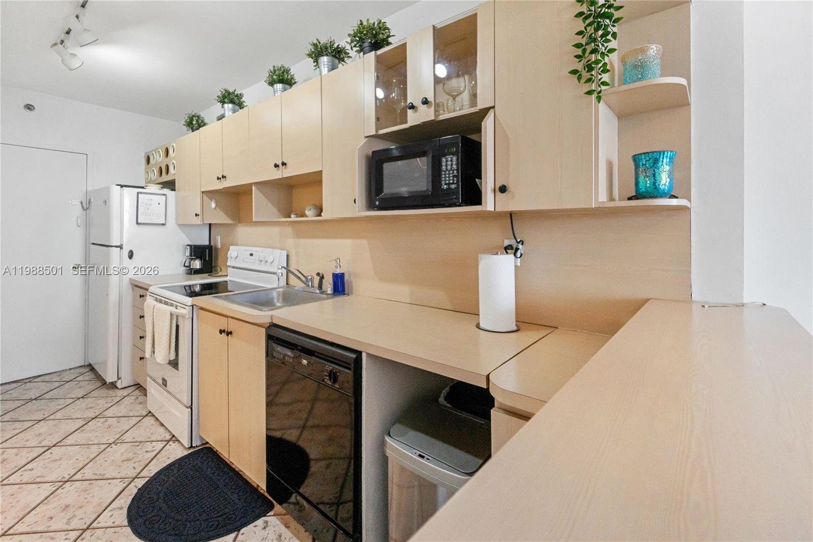 100 Lincoln Road, Unit 818 Miami Beach, FL 33139 - Photo 8 of 18 a kitchen with a sink dishwasher and a stove with wooden floor