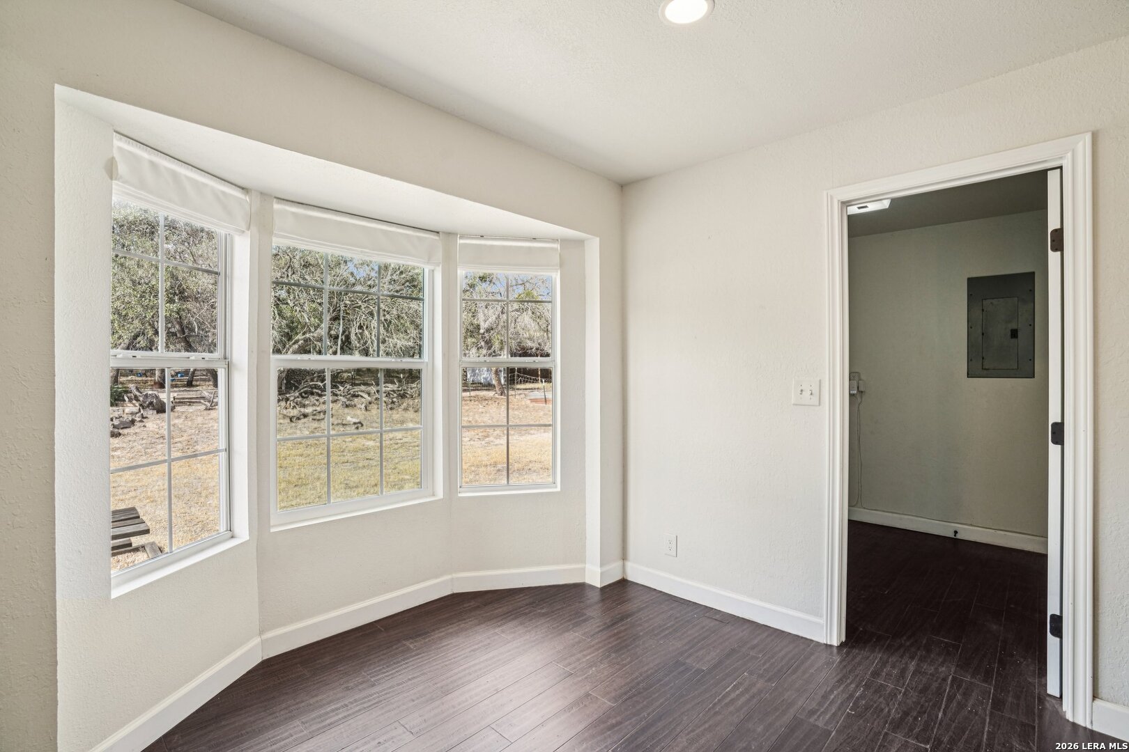 706 Quail Run Lytle, TX 78052 - Photo 16 of 51 an empty room with wooden floor and windows