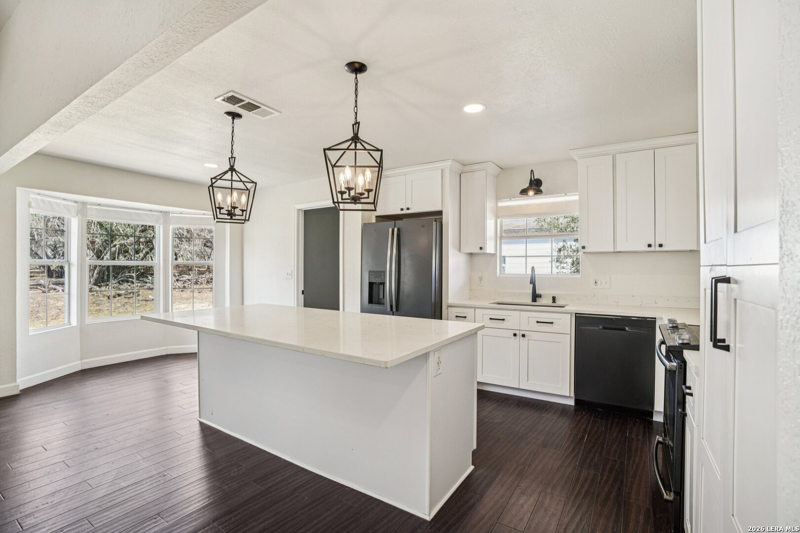 706 Quail Run Lytle, TX 78052 - Photo 18 of 51 a open kitchen with stainless steel appliances granite countertop a stove refrigerator and a wooden floor