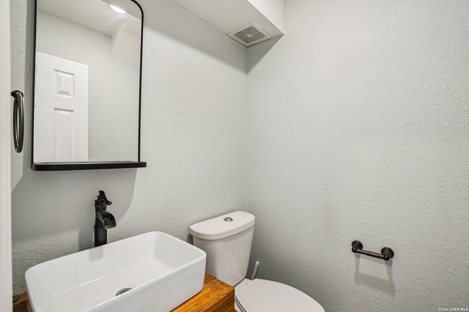 706 Quail Run Lytle, TX 78052 - Photo 27 of 51 a bathroom with a toilet a sink and mirror