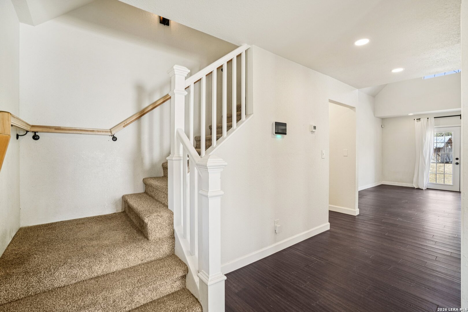 706 Quail Run Lytle, TX 78052 - Photo 30 of 51 a view of a hallway with wooden floor and staircase
