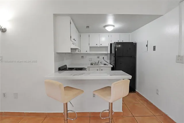 a kitchen with stainless steel appliances a stove a refrigerator and white cabinets